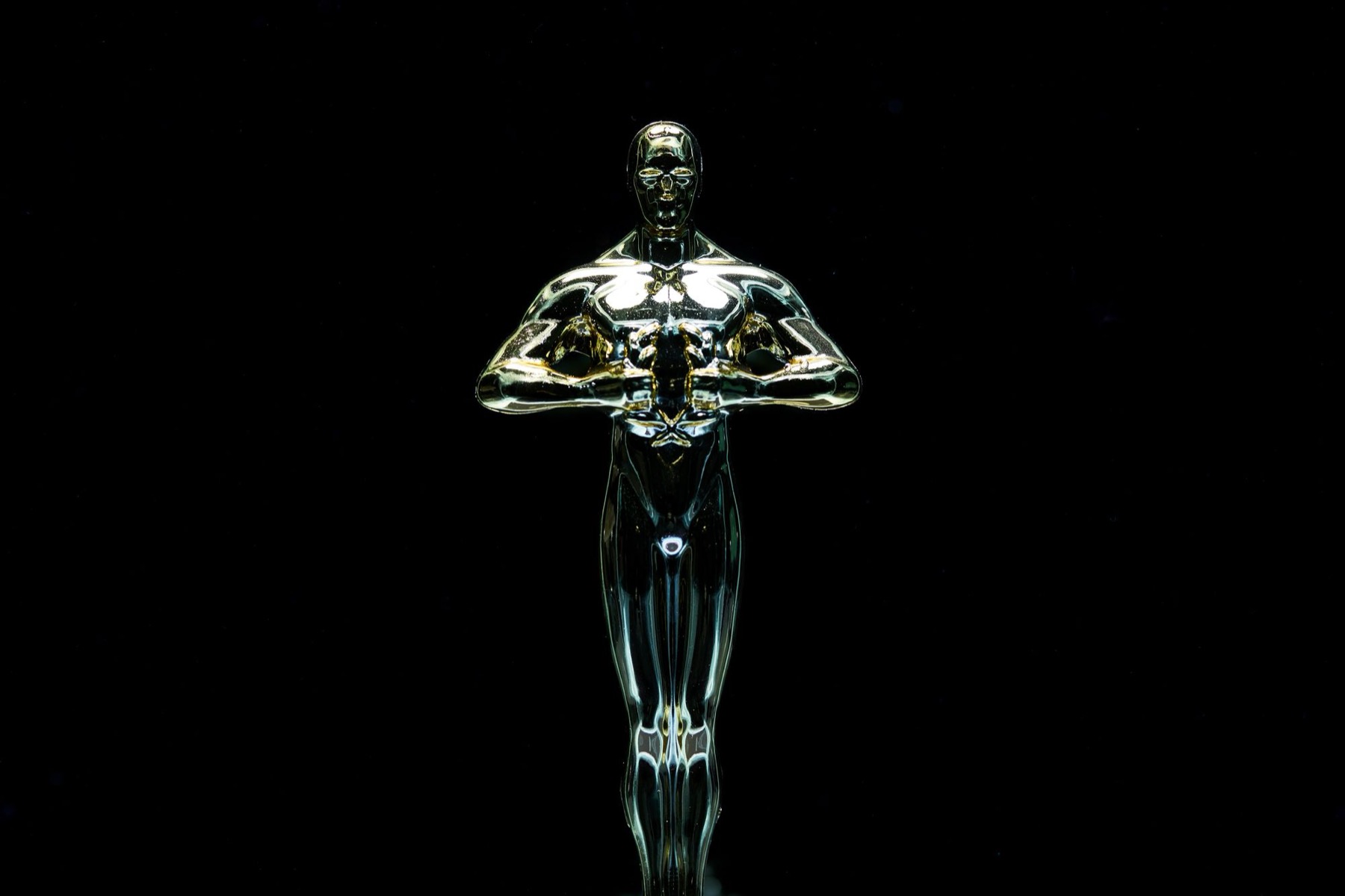 A gold trophy figure standing against a plain black background.